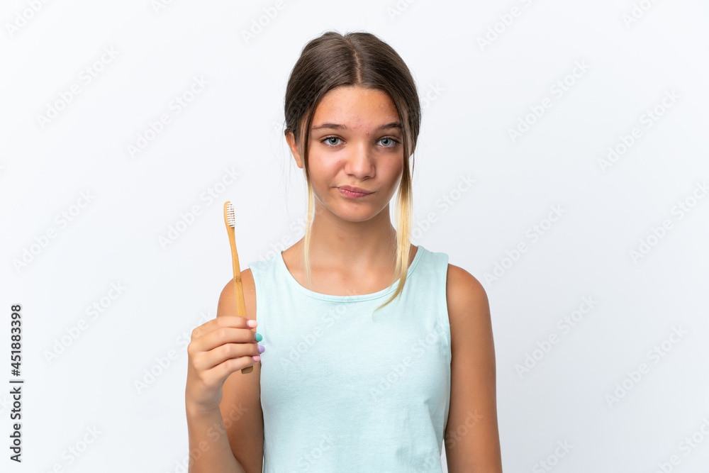 Little caucasian girl holding a toothbrush isolated on white background with sad expression Little caucasian girl holding a toothbrush isolated on white background with sad expression