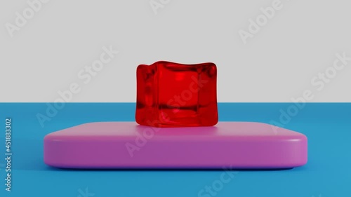 An animated slow motion of a red jello cube dropping on the pink plastic rectangle in the white and light-blue background photo