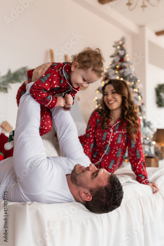 Merry Christmas and Happy Holidays. Happy mom, dad and daughter are happy. The morning before Christmas. Close-up portrait of a loving family