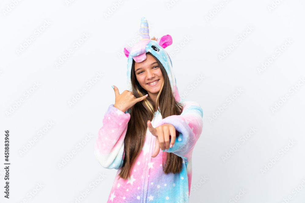Little caucasian girl wearing unicorn pajama isolated on white background making phone gesture and pointing front