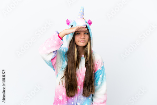 Little caucasian girl wearing unicorn pajama isolated on white background looking far away with hand to look something