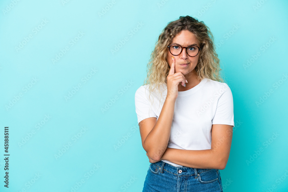 Girl with curly hair isolated on blue background and thinking Girl with curly hair isolated on blue background and thinking