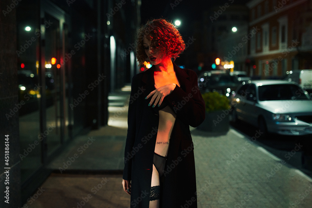 Fototapeta premium The cloaked Lead walks around the city at night. Shooting in the style of cinema