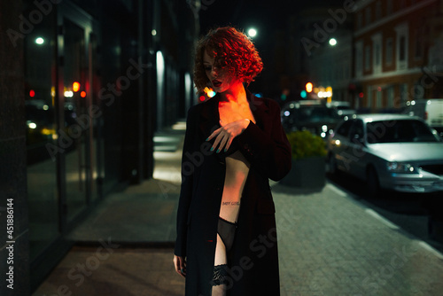 The cloaked Lead walks around the city at night. Shooting in the style of cinema photo