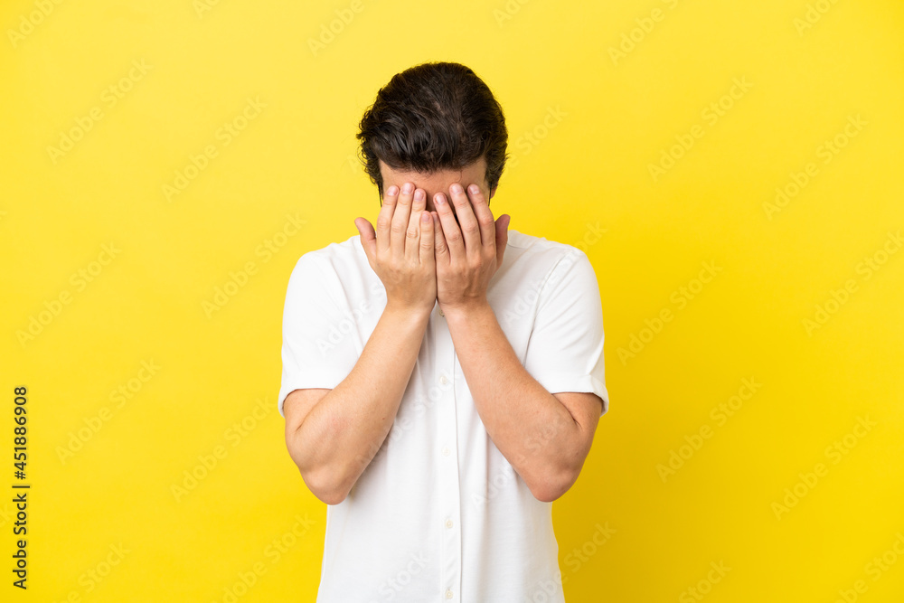 Young caucasian man isolated on yellow background with tired and sick expression