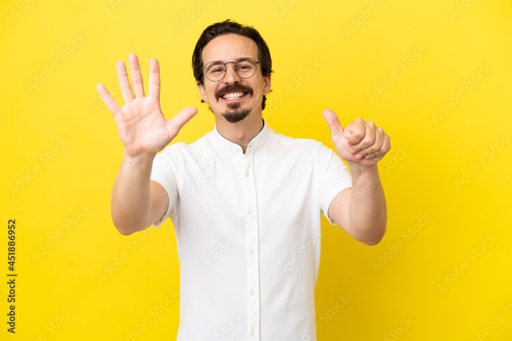 Young caucasian man isolated on yellow background counting six with fingers Young caucasian man isolated on yellow background counting six with fingers
