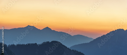 Atmospheric alpine landscape with silhouettes of mountains with trees at twilight in the morning, Slovenia © Sebastian
