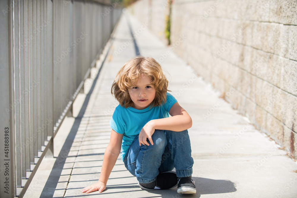 Boy kid take rest sitting down on promenade on summer outdoors, resting Boy kid take rest sitting down on promenade on summer outdoors, resting