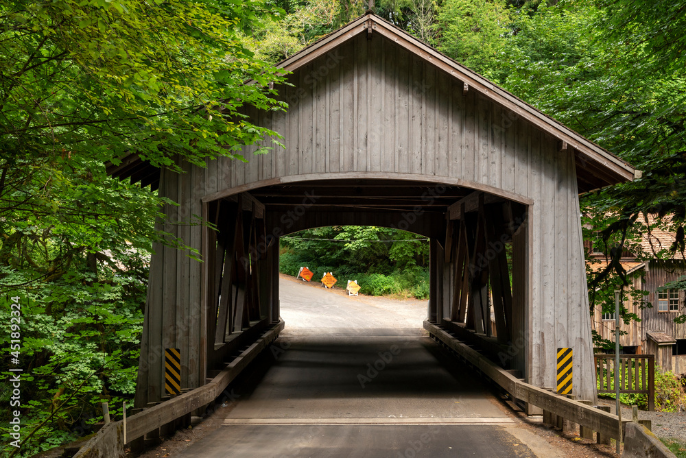 Covered bridge and road signs in wooded area Covered bridge and road signs in wooded area