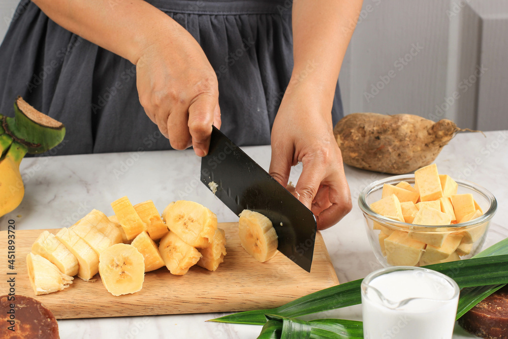 Slicing Banana, Preparation making Banana and Sweet Potato Compote (Kolak Pisang Ubi). Ripe Banana, Sweet Potato, Palm Sugar, Pandan Leaves, and Coconut Milk. Slicing Banana, Preparation making Banana and Sweet Potato Compote (Kolak Pisang Ubi). Ripe Banana, Sweet Potato, Palm Sugar, Pandan Leaves, and Coconut Milk.