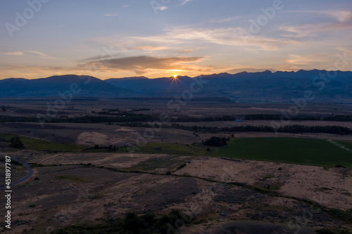 Aerial view of the sun setting behind the Gallatin Mountains near Pray (Paradise Valley) Montana.