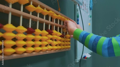 Baby counting on abacus playing in daycare with financial tools, elementary education Close up. High quality 4k footage photo