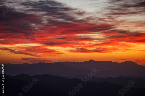 真っ赤な朝焼けの雲が稜線上に流れる © Hiro29