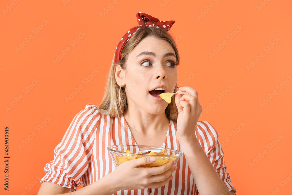 Beautiful young woman eating tasty nachos on color background Beautiful young woman eating tasty nachos on color background