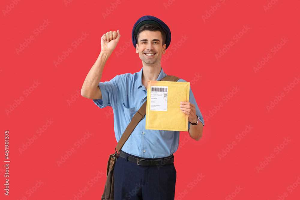 Handsome young postman with letter on color background Handsome young postman with letter on color background