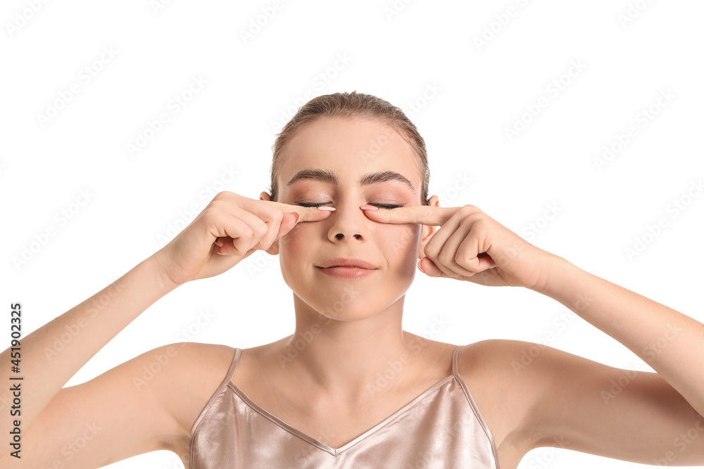 Beautiful young woman doing facial yoga on white background