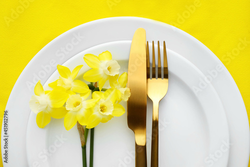 Beautiful table setting with narcissus flowers, closeup