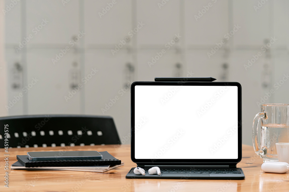 Fototapeta premium Mockup blank screen tablet with magic keyboard on wooden table in locker room.