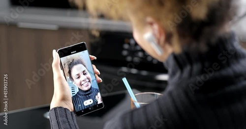 Black woman blogger holds a mobile phone and records a blog on the camera. Happy young african american teen girl blogger vlogger doing online video chat call record vlog blog talking to camera.