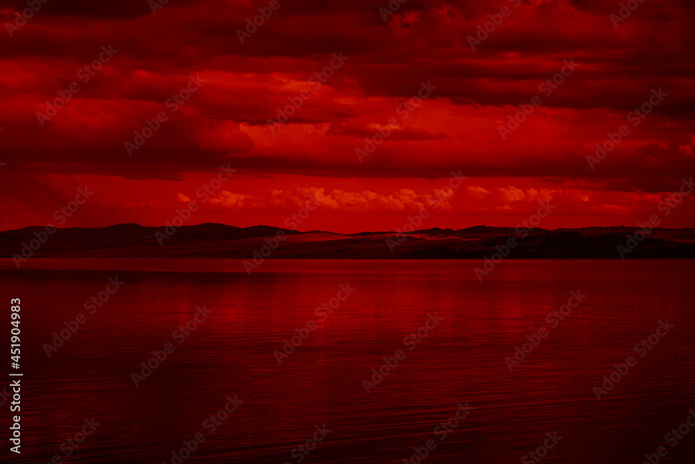 The surface and the island of red water scenery. Sky with clouds. Bloody sunset background with copy space for design. War, apocalypse, armageddon, nightmare, halloween, evil, horror concept.