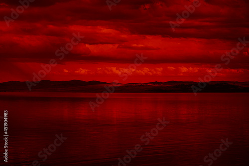 Obraz na płótnie The surface and the island of red water scenery. Sky with clouds. Bloody sunset background with copy space for design. War, apocalypse, armageddon, nightmare, halloween, evil, horror concept. w salonie