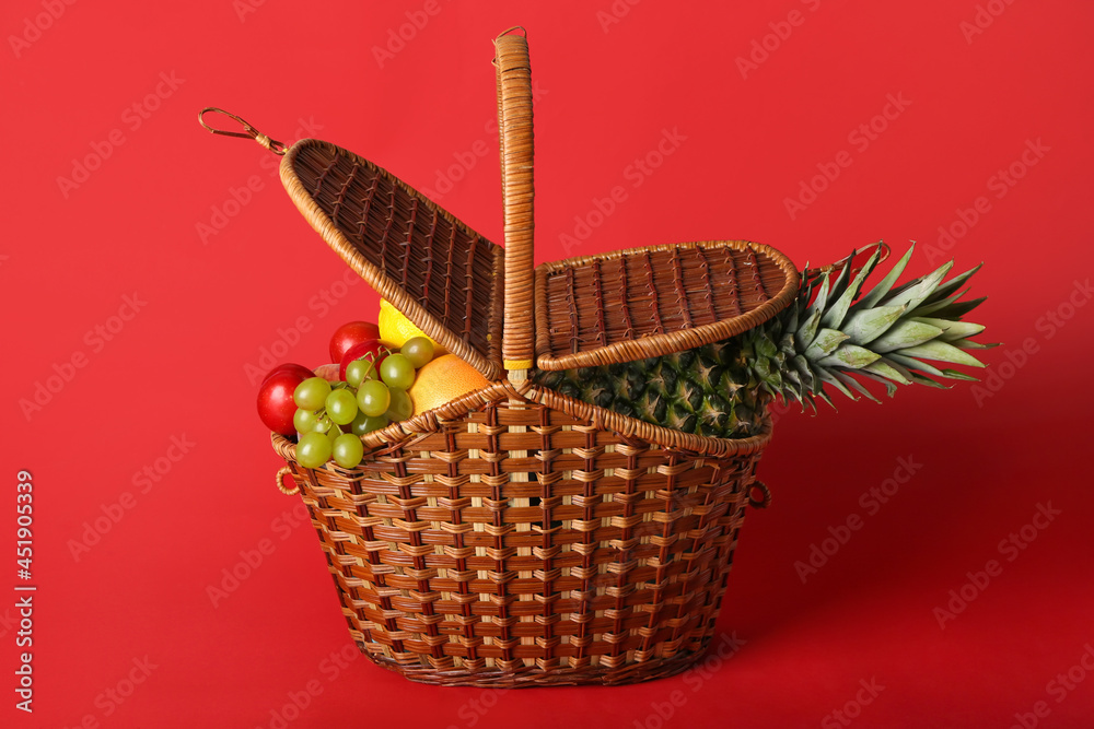 Basket with fresh fruits on color background Basket with fresh fruits on color background