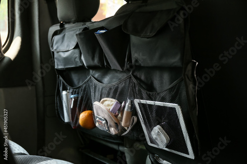 Travel organizer with different things on car seat, closeup photo