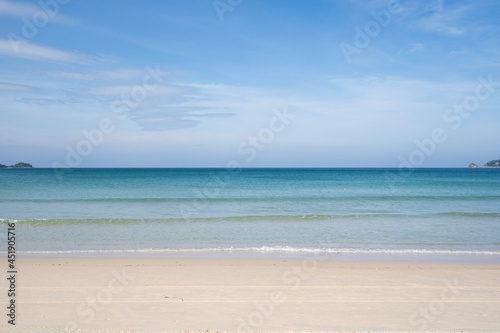 Tropical sandy beach with blue ocean and blue sky background image for nature background or summer background. © panya99
