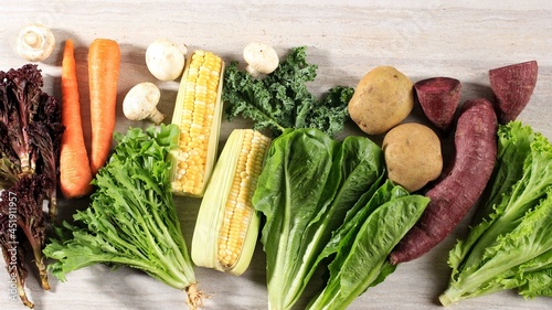 Healthy Food, Various fresh  Vegetables Leaf On a Brown Marble Wooden Background. Top View. Copy Space. Kale, Lettuce, Purple Lettuce, Endive, Carrot, Mushroom, Corn, Puplre Sweet Potato, Potato