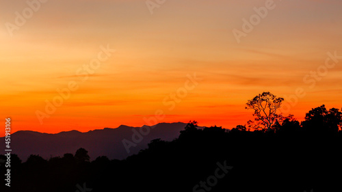 sunrise or sunset with mist and mountain. Orange sky.