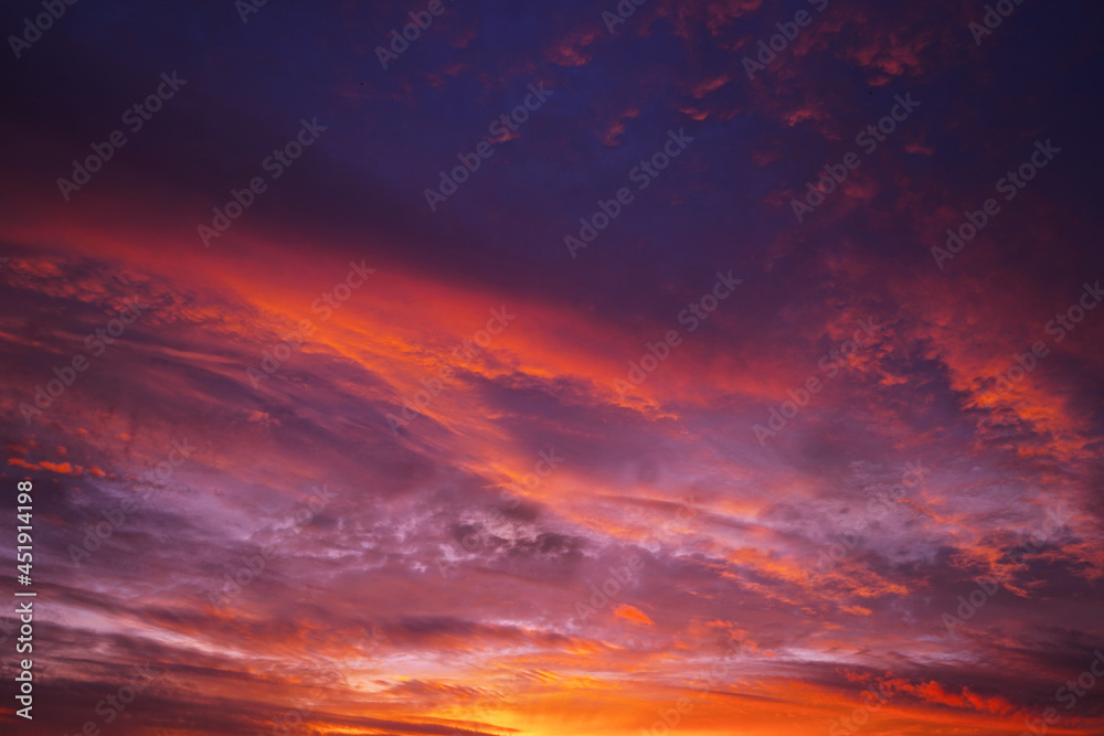 Purple red orange sunset. Colorful sky with clouds background for design.