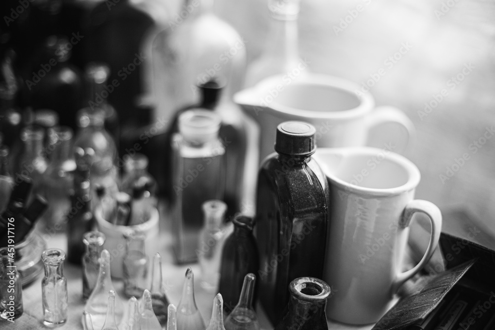 Many Old Deutsch Vintage Medical Glass Capacity. Detail Of Retro Chemical Pharmaceutical Science Researches. Small Bottles Different Sizes From Times Of World War II. WW2 WWII. Black And White