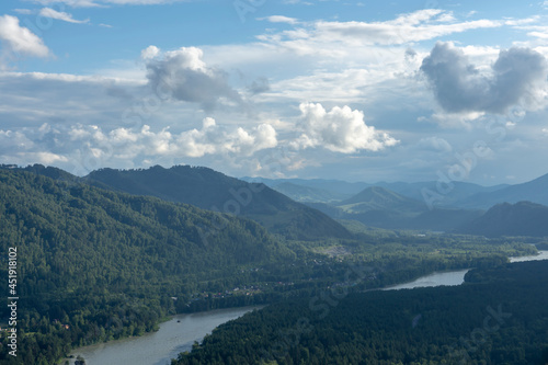 white fluffy clouds on blue sky and mountain peaks