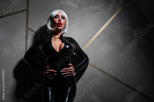 Samolepka Sexy woman in a blonde wig and latex catsuit. Role-playing games