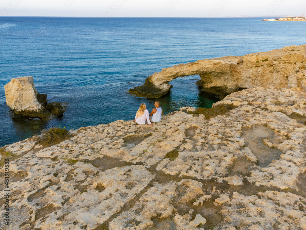 Young Couple in love at bridge of love in Ayia Napa, Cyprus, smiling, laughing. Kisses and love.