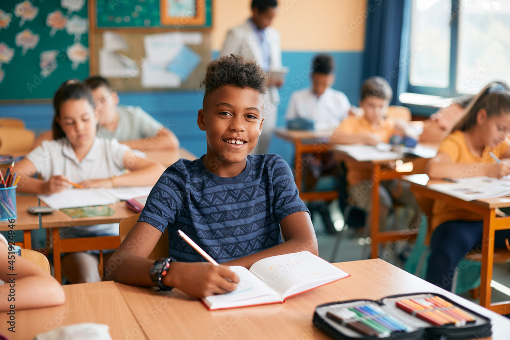 Happy African American schoolboy during class at elementary school. Happy African American schoolboy during class at elementary school.