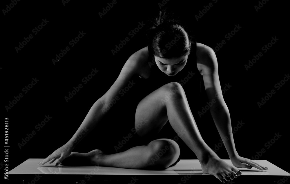 Silhouette of 20s Asian Woman teacher present Yoga body shape in light shadow for sensual look