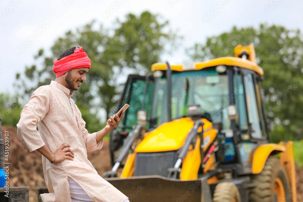 Young indian farmer talking on smartphone