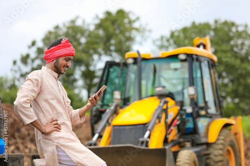 Young indian farmer talking on smartphone
