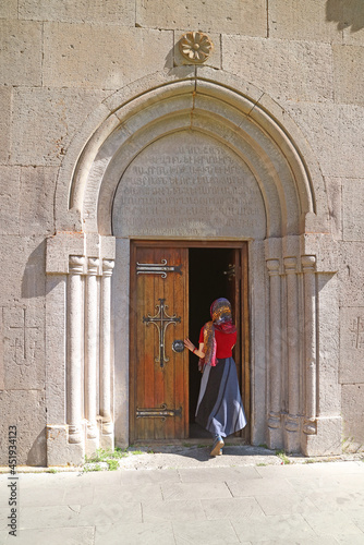 Woman with chapel veil entering to the Katoghike (cathedral) church of Kecharis medieval monastic complex in Tsakhkadzor town, Armenia