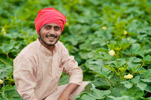 Young Indian farmer at green agriculture field.