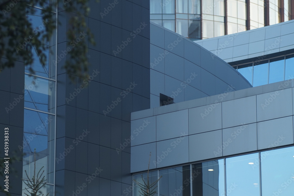 Obraz premium Photo of the textures of the business center of a big city. Glass and concrete. Iron and stone are tied in a tight knot. Verticals, horizontals, diagonals, radial lines and stripes.