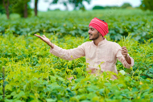 Young indian farmer at agriculture field.