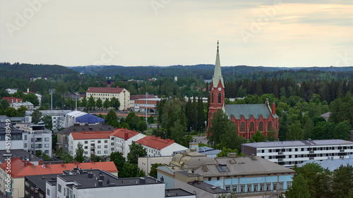 Panorama of the city of Mikkeli in Finland before the rain in summer: roofs of houses horizon forest lutheran church.