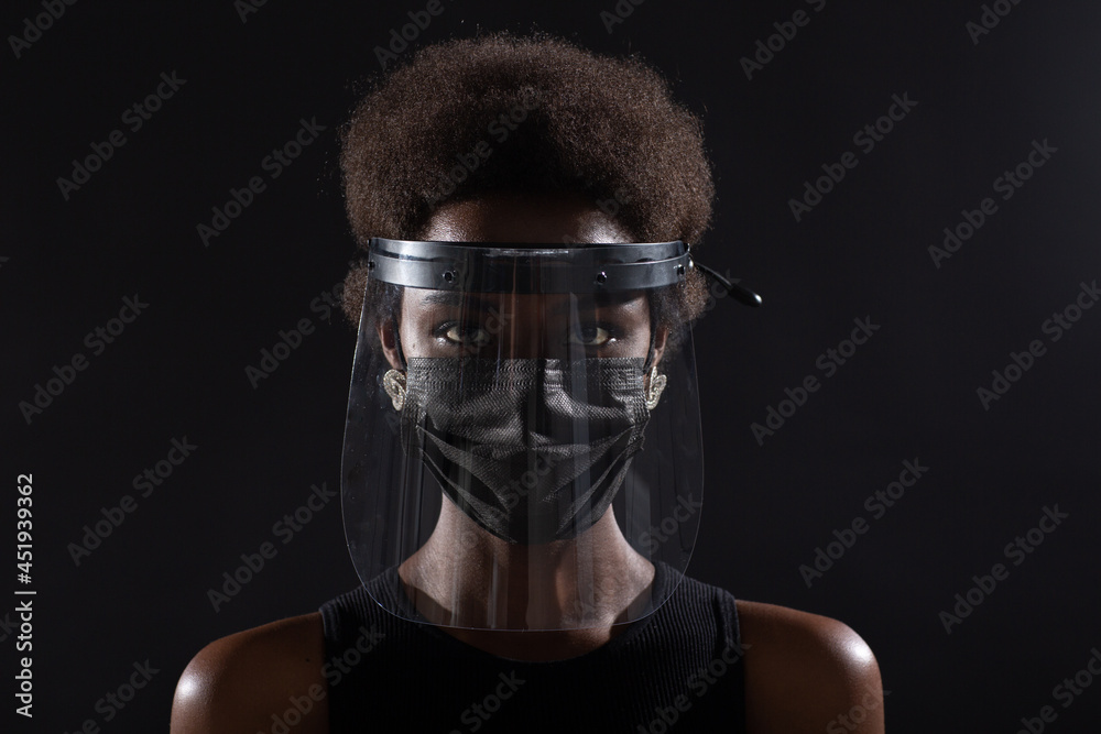 African american woman in black medical face mask and transparent protective face shield. Safety concept Covid-19 coronavirus protection.