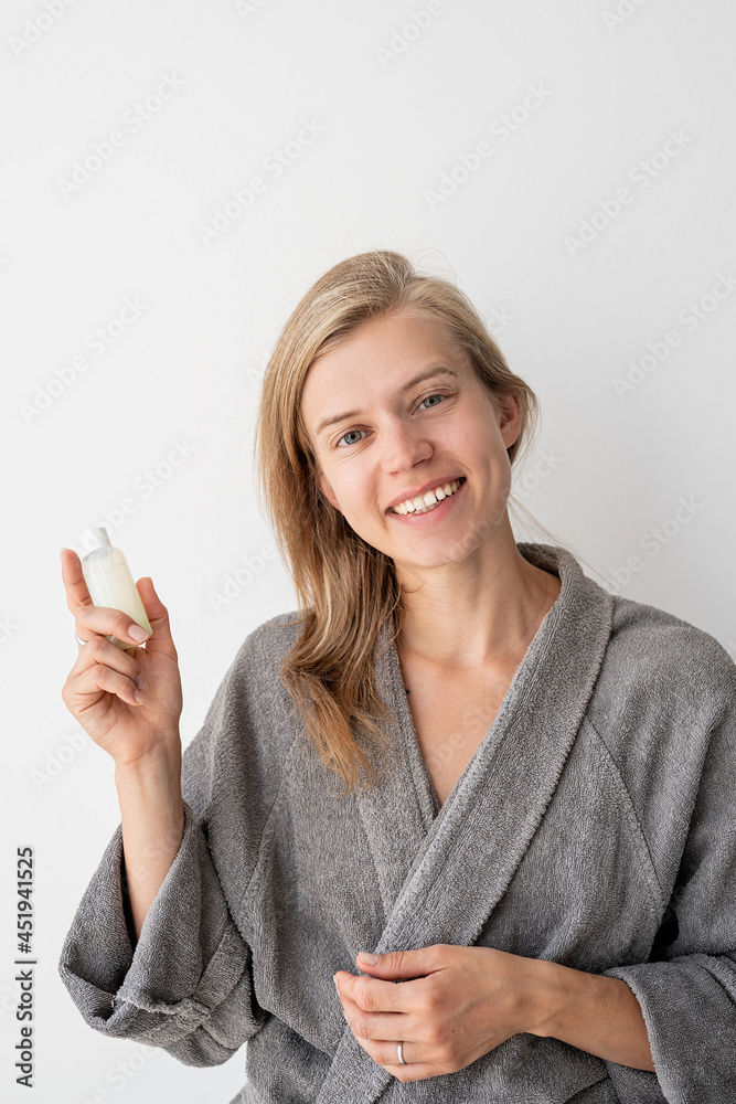 Young woman holding bottle with beauty product Young woman holding bottle with beauty product
