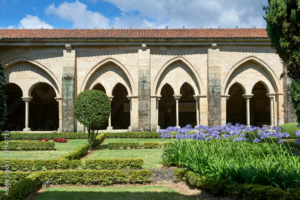 cloister with Gothic arches, columns and capitals, and interior garden with hedge