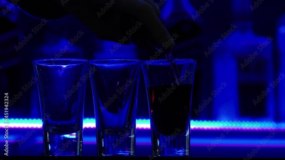 Pouring Three Shots is an excellent stock video that contains a close-up shot of a bartender's hand pouring three shots of tequila into three small glasses.