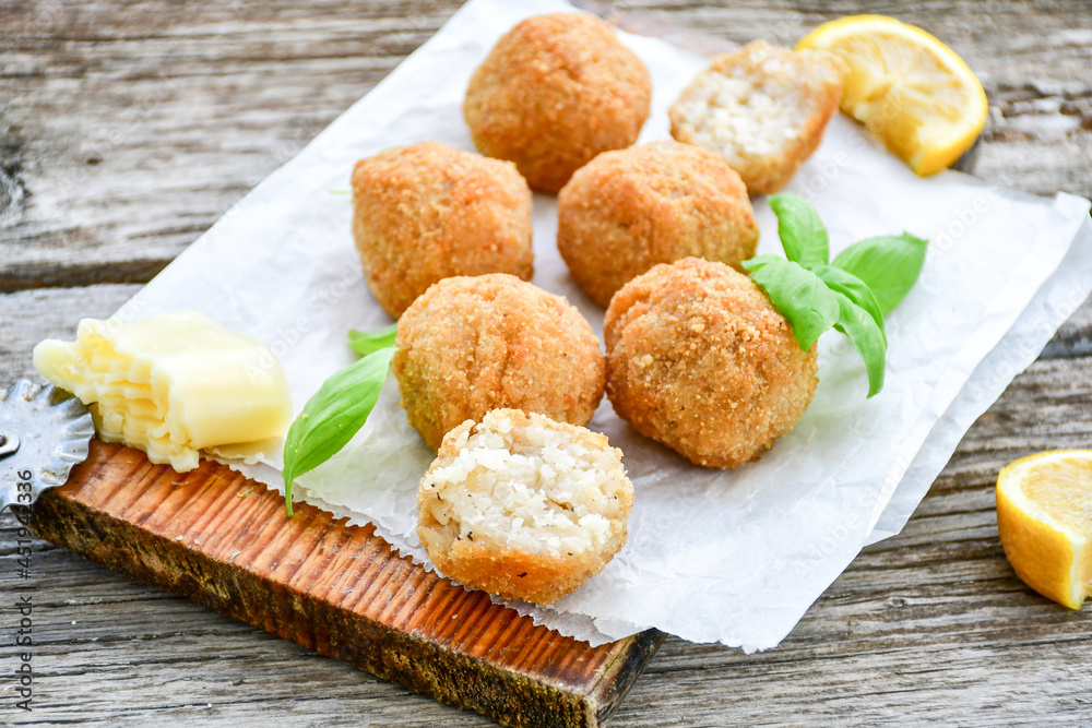 Italian arancini Cacio e pepe. Homemade rice balls with mozzarella cheese, parsley, lemon, and