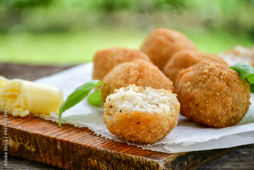 Italian arancini Cacio e pepe. Homemade rice balls with mozzarella cheese, parsley, lemon, and